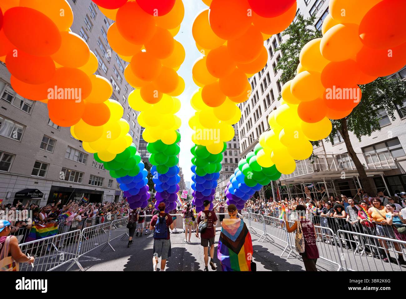 Rainbow-colored balloons are moved down 6th Avenue during the NYC Pride ...