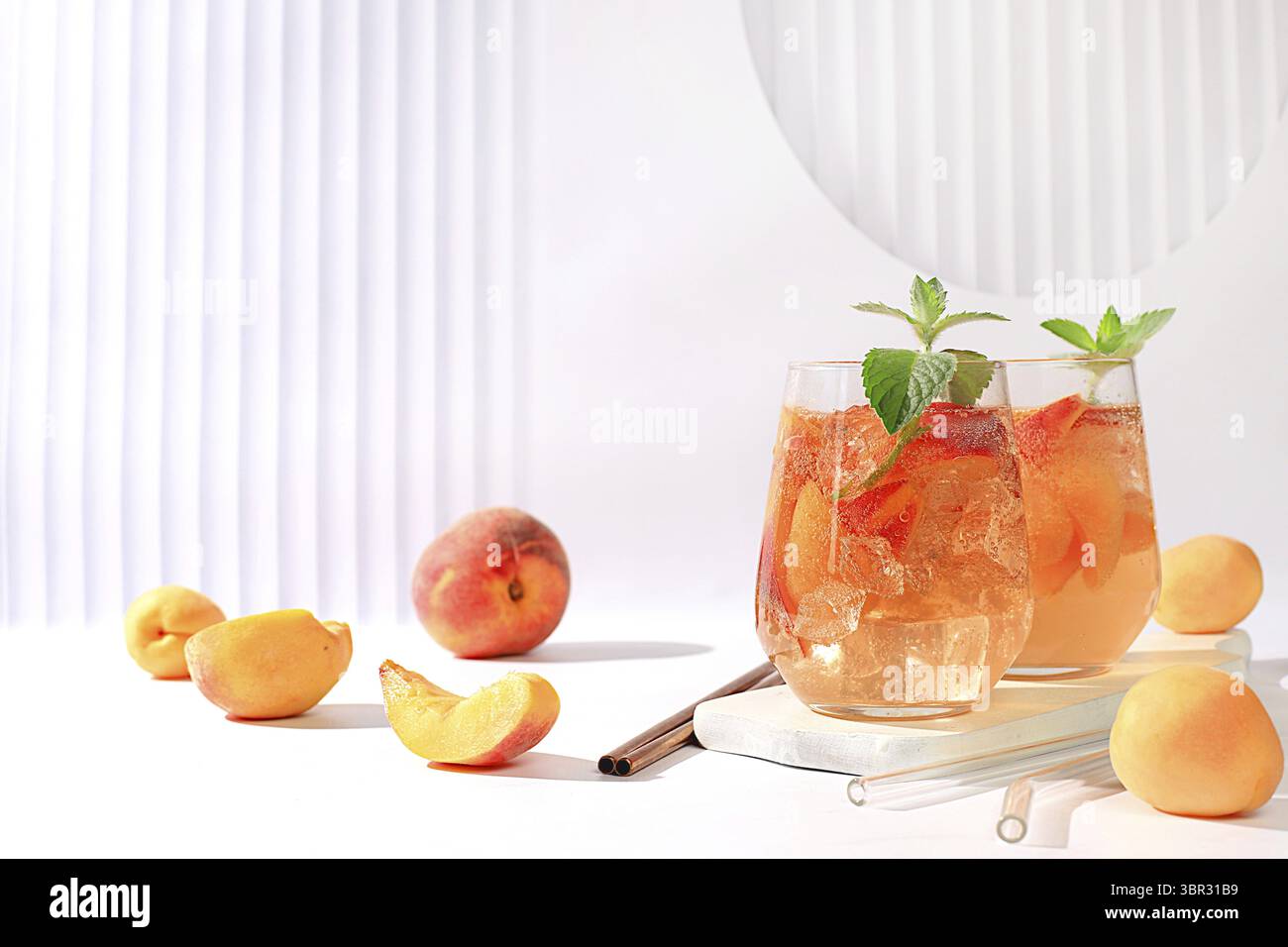 Eis Pfirsich Tee oder Cocktail mit Minze und Aprikosen, ein Rezept fuer ein erfrischendes Sommergetraenk. Zwei Glaeser mit Pfirsich Frucht Limonade au Stock Photo