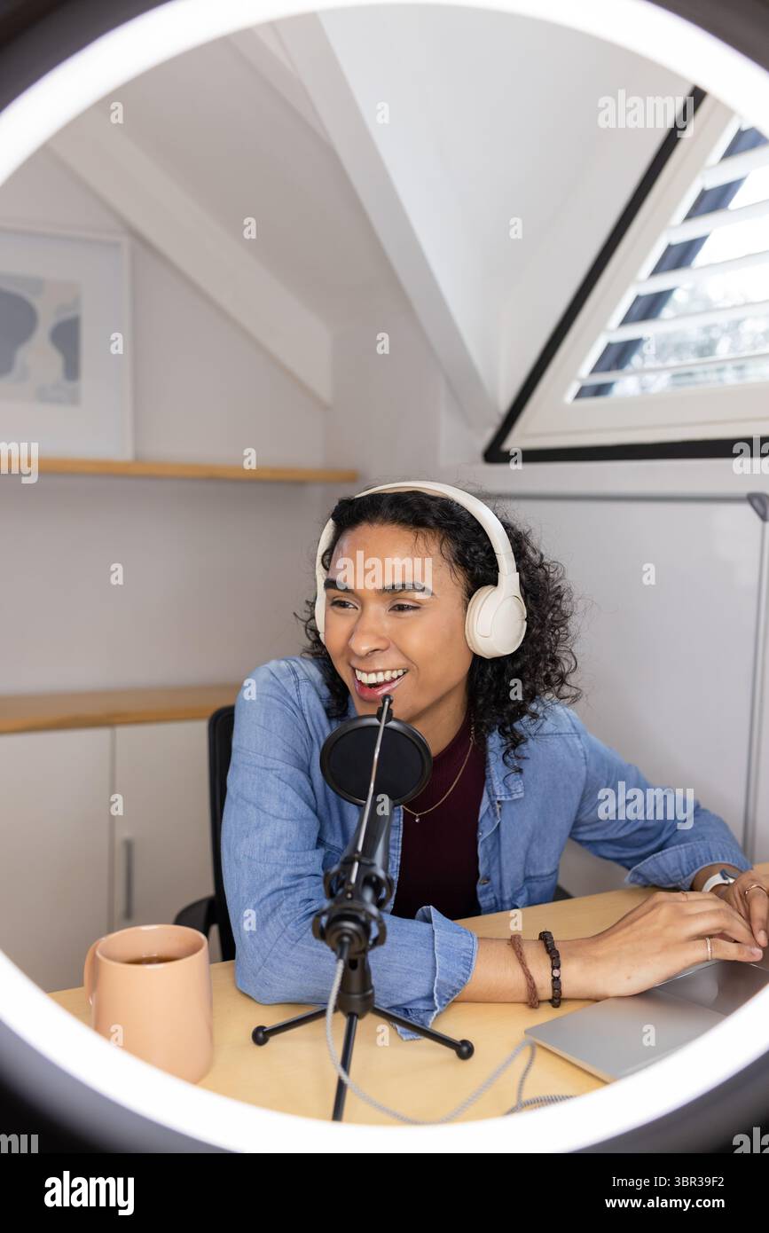 Podcaster Using A Microphone Non-binary podcaster wearing denim shirt using microphone at converted ...