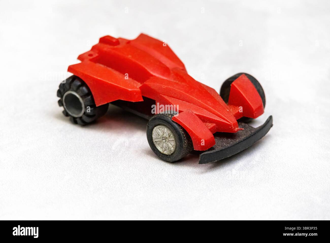 Classic red plastic F1 racing car toy, close-up view. Children's ...