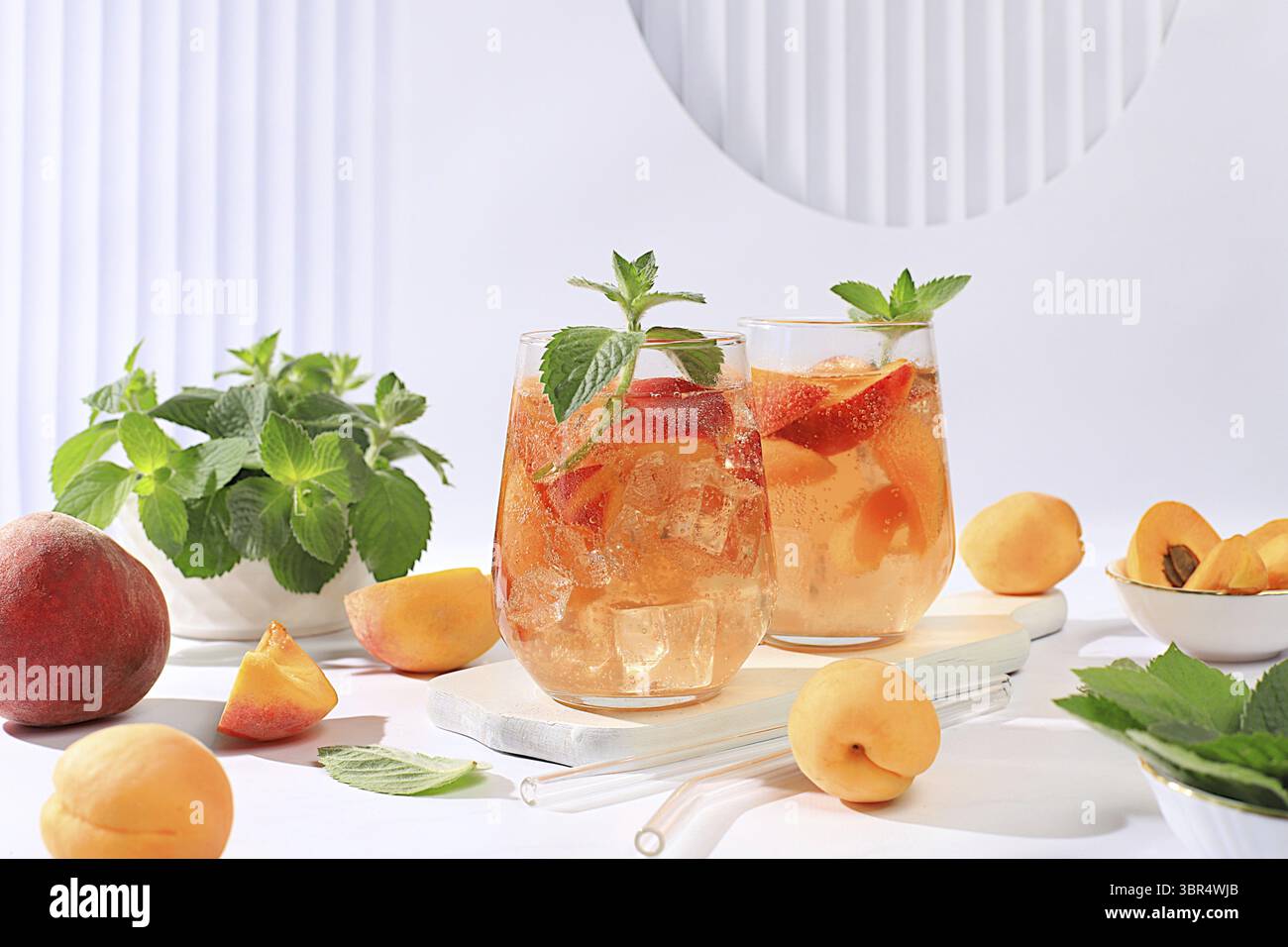 Eis Pfirsich Tee oder Cocktail mit Minze und Aprikosen, ein Rezept fuer ein erfrischendes Sommergetraenk. Zwei Glaeser mit Pfirsich Frucht Limonade au Stock Photo