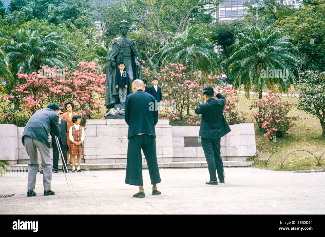 Sunday outings family photo, Mid Levels, Botanical Gardens, Hong Kong, Asia, 1964 children pose by bronze statue of King George VI Stock Photo