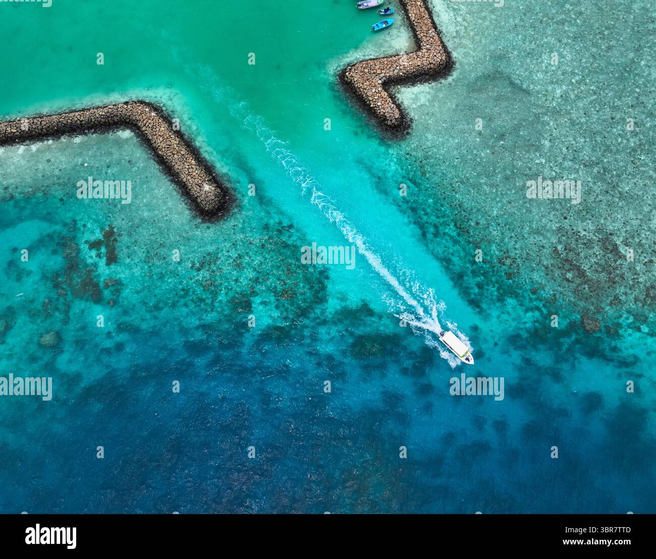 Aerial view of a boat slicing through turquoise waters, leaving a white ...