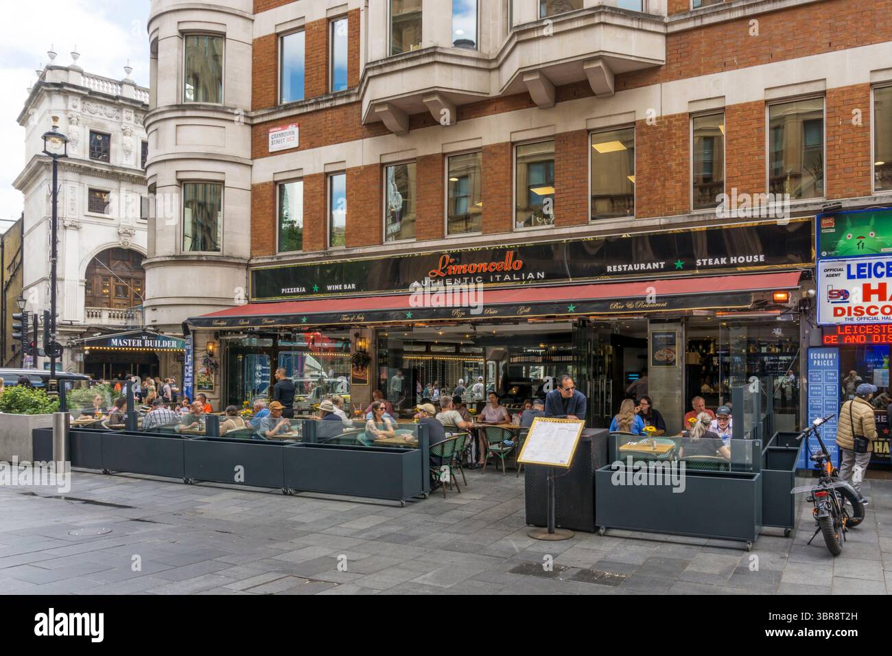 People sitting outside Limoncello Italian restaurant in Cranbourn Street, central London. Stock Photo