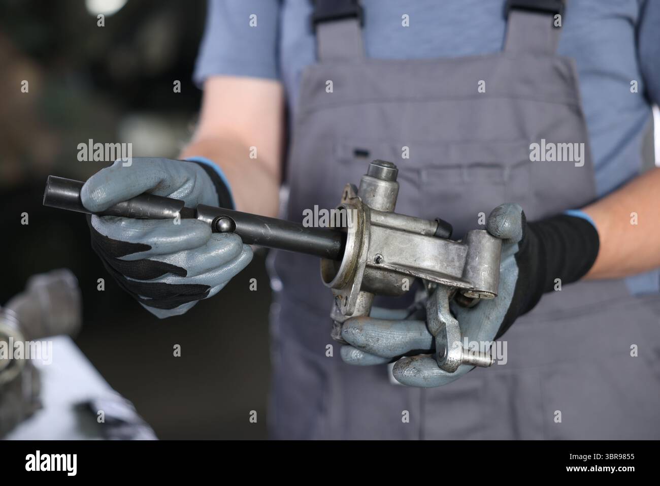 Auto part. Professional mechanic with manual transmission indoors, closeup Stock Photo