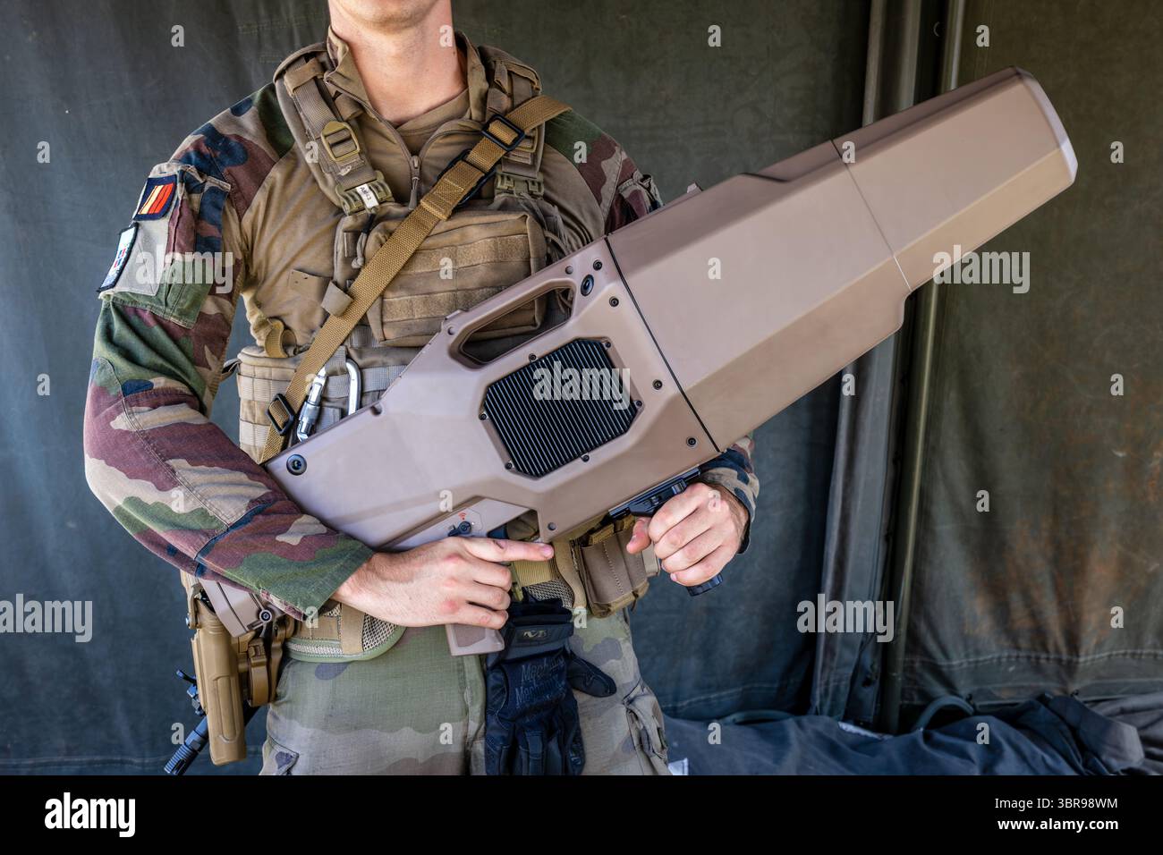 A French Army soldier is holding before him a NEROD RF rifle, a portable multi-frequency directional anti-drone jammer made by MC2 Technologies. Stock Photo