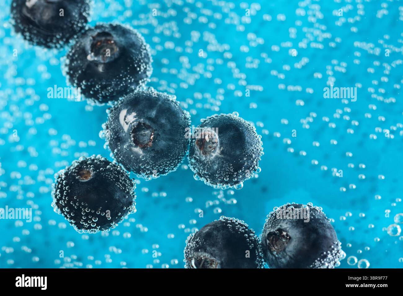 Fresh blueberries float in sparkling water, surrounded by bubbles ...