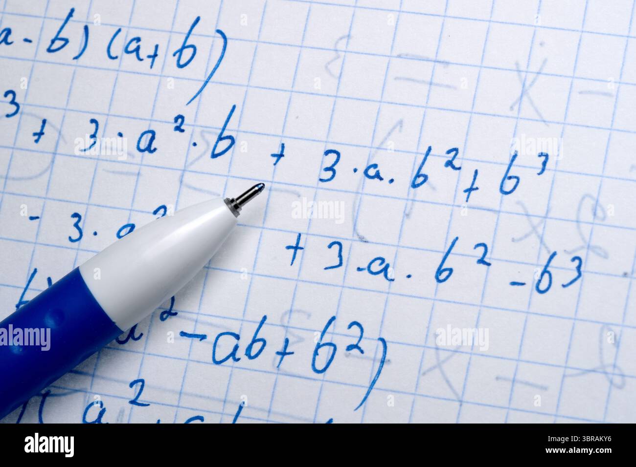 A pen hovers over detailed math calculations on graph paper Stock Photo ...