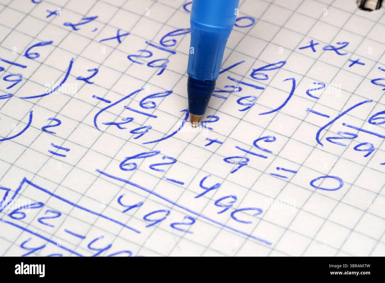 Multiple mathematical equations are intricately written in a notebook. Stock Photo