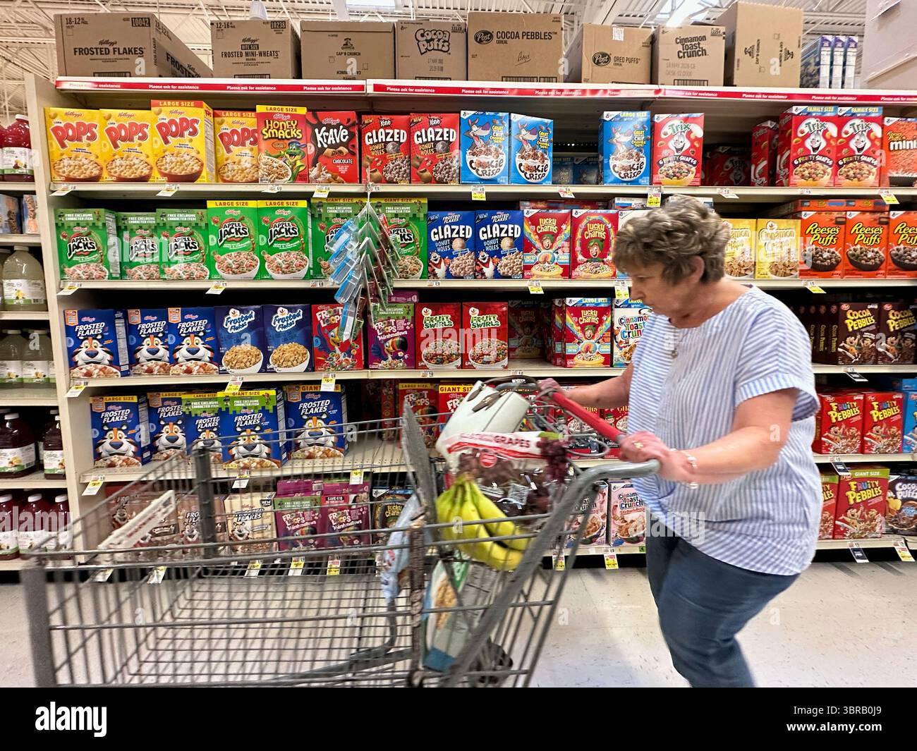A woman pushes a shopping cart past boxes of Kellogg #39 s breakfast cereal A woman pushes a shopping cart past boxes of Kellogg #39 s breakfast cereal