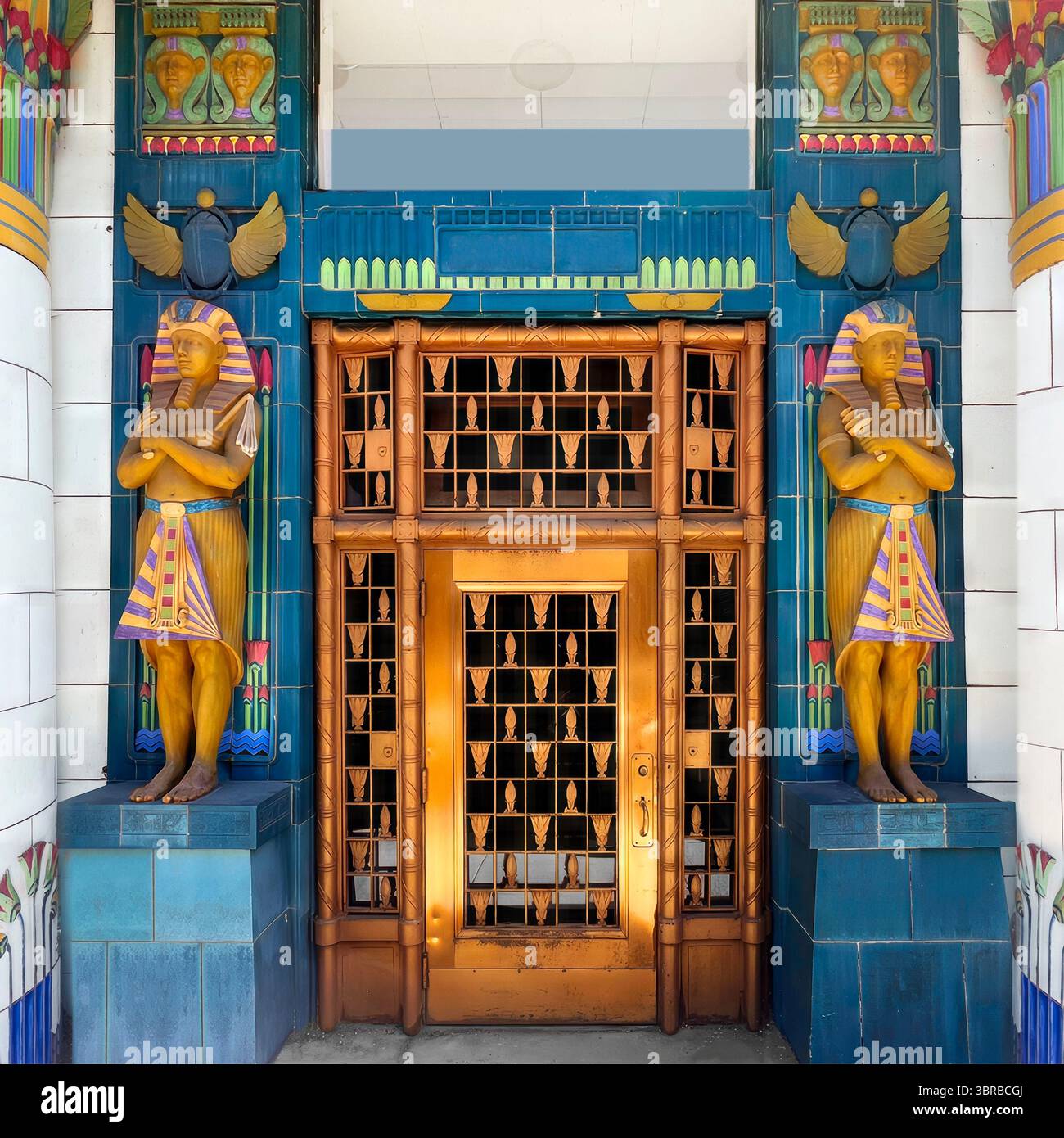 Egyptian Revival doorway of a 1920s Art Deco storage building in Chicago, featuring vibrant pharaoh statues, winged scarabs, and stylized lotus motifs. - Smartphone Captured Stock Image