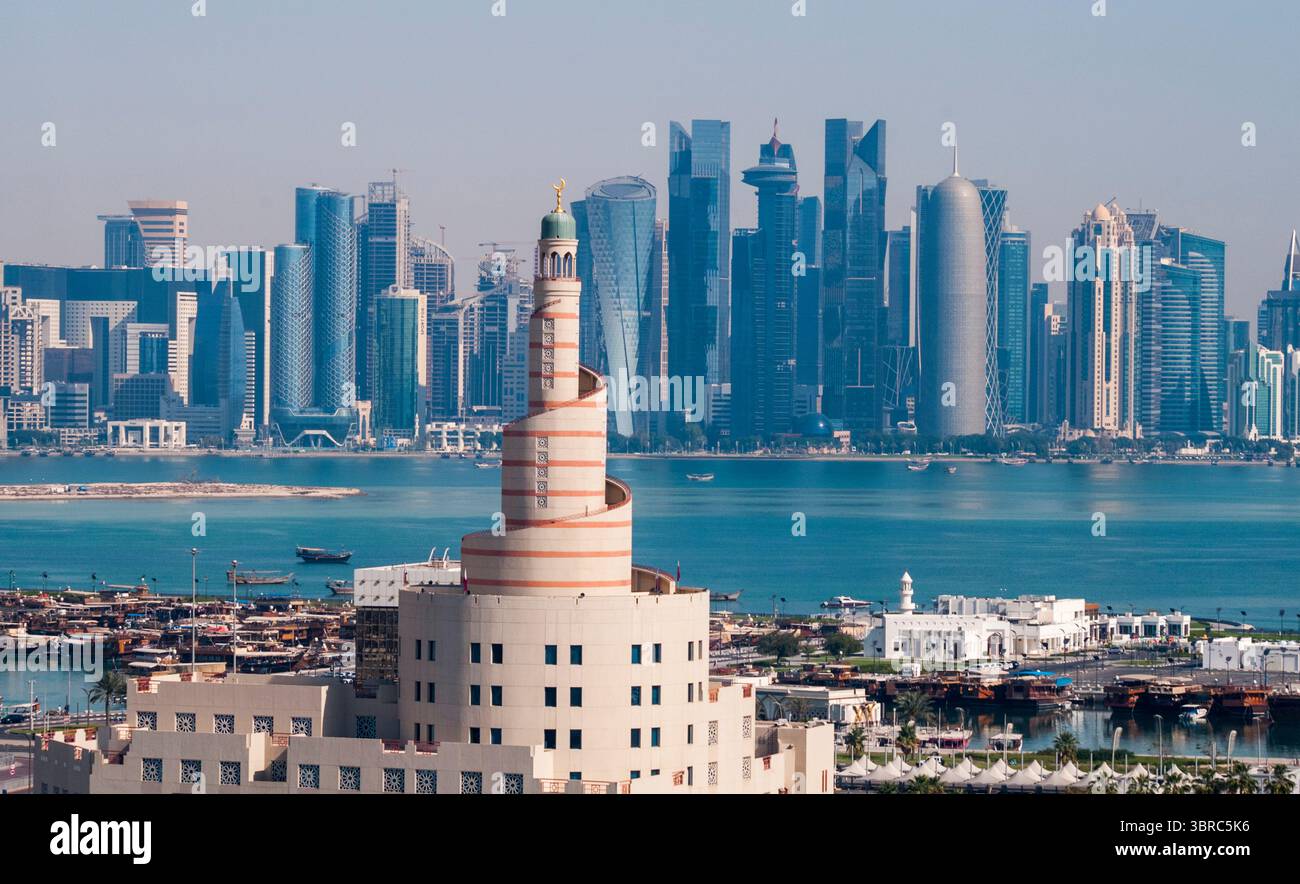 Spiral minaret of the Fanar Islamic Cultural Centre, with The Pearl Island beyond. Doha, Qatar Stock Photo