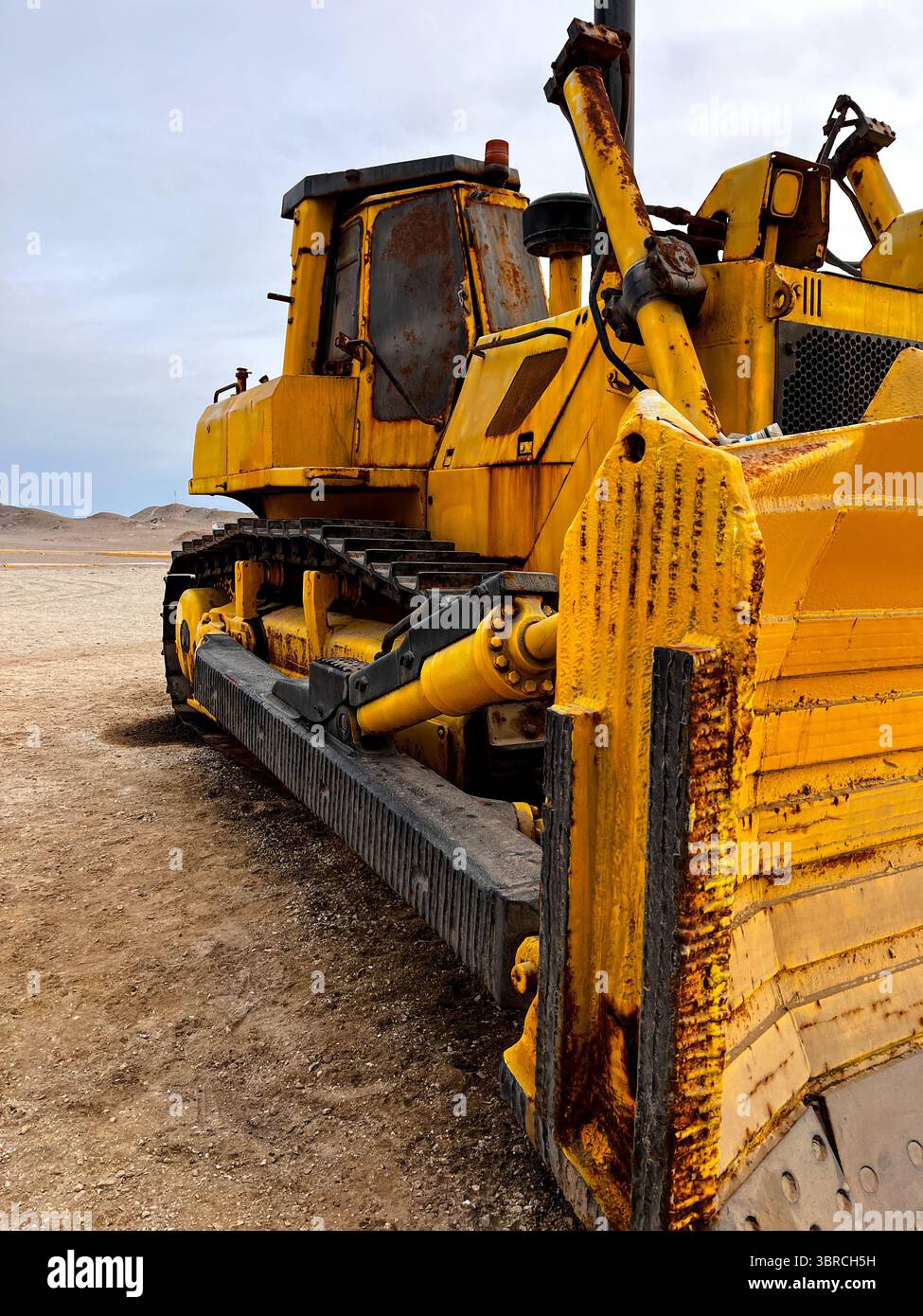 Close up from the side of  heavy old rusty mining vehicle out of work standing for exhibition on the coast of Peru in San Juan de Marcona Stock Photo