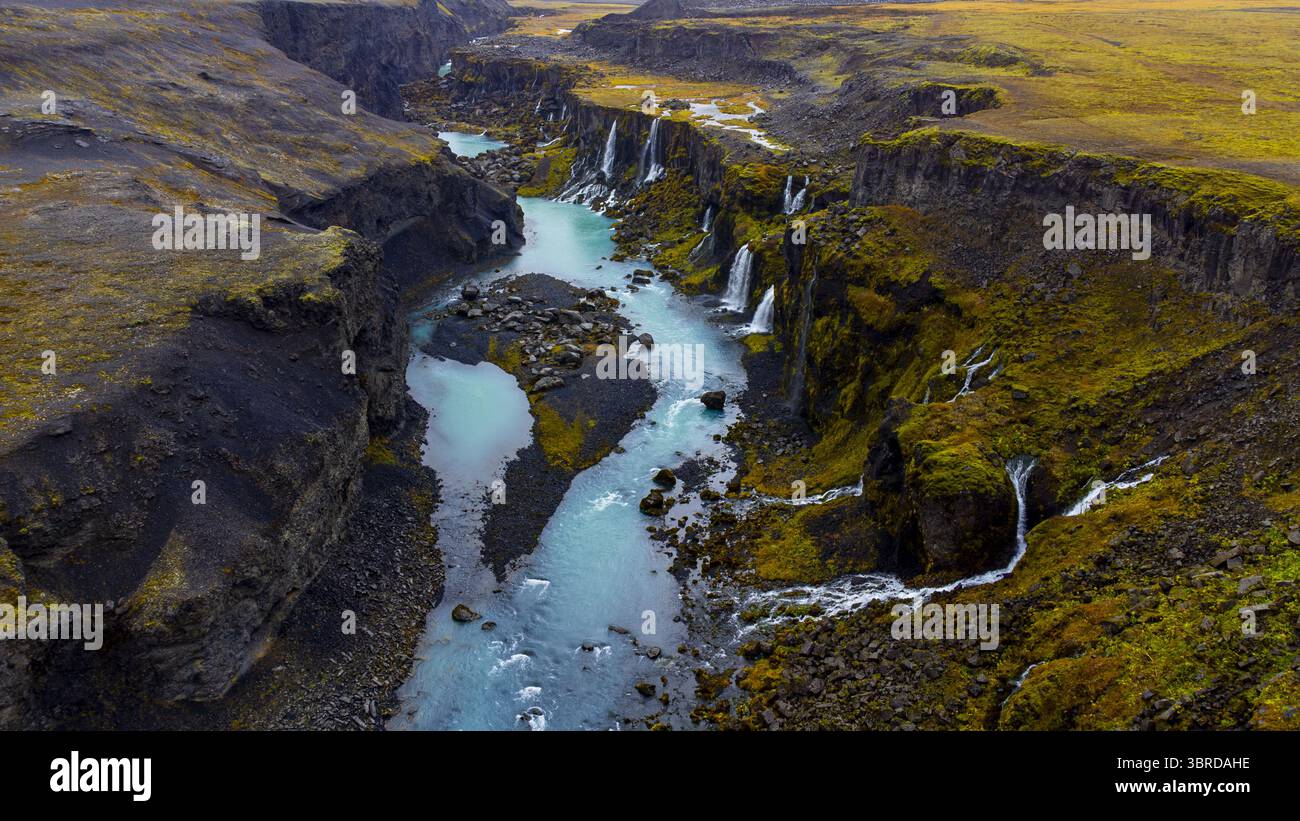 Aerial view of turquoise waters cutting through rugged, moss-covered ...