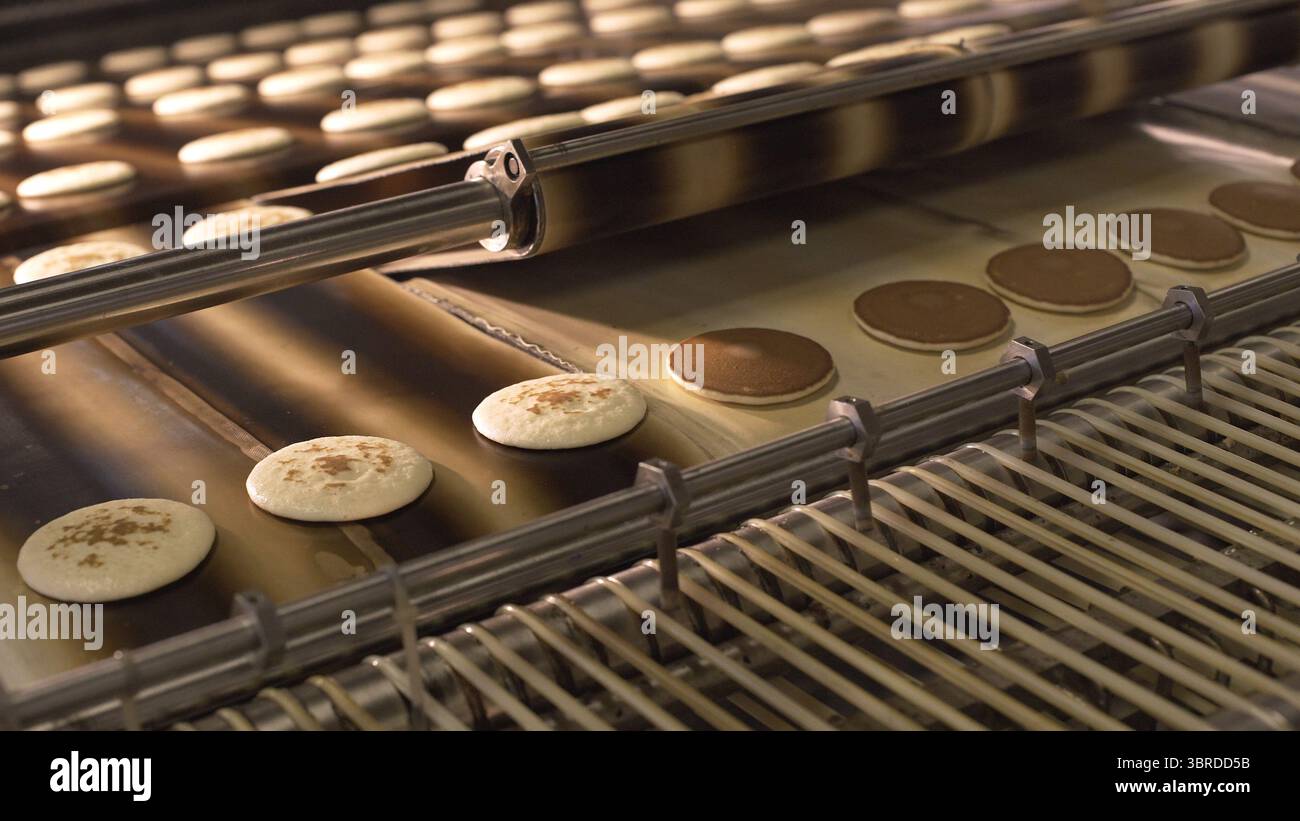 Sequence of images showing an industrial machine pressing round dough ...