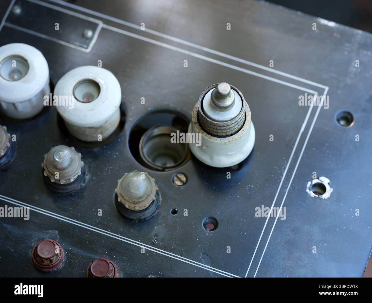 White ceramic plug fuse on an old black electrical panel Stock Photo