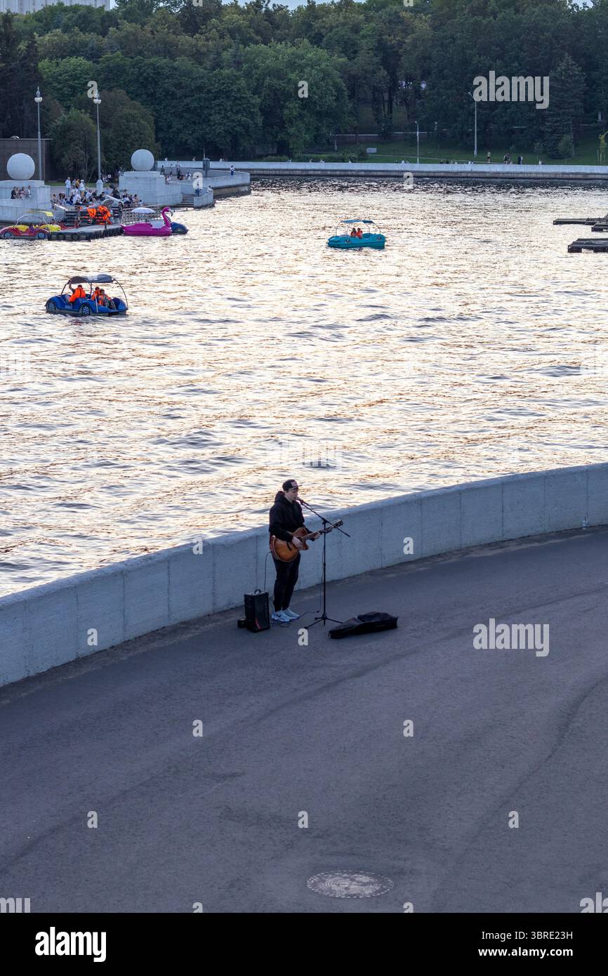 07.07.2025- Minsk, Belarus - Street performer singing by the Svislach river in the city. Stock Photo