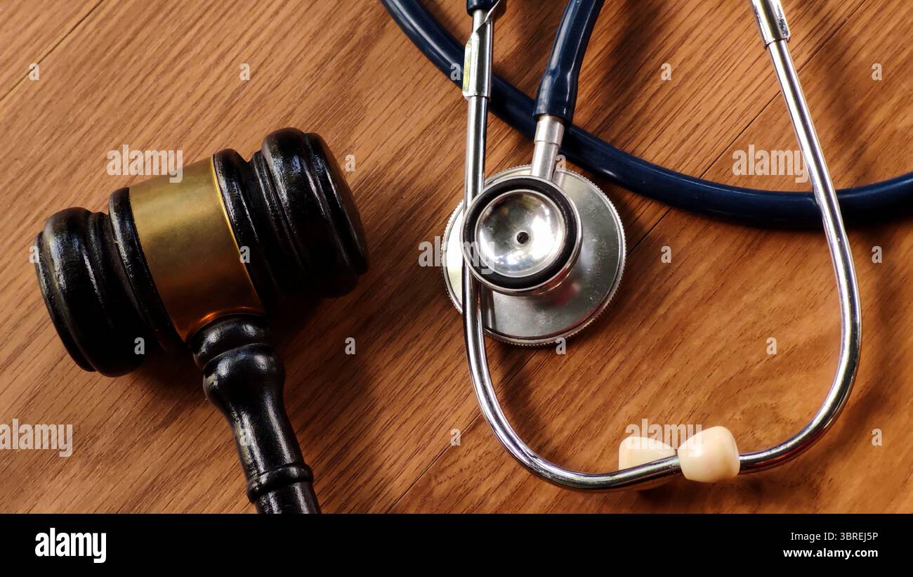 Gavel and Stethoscope on Wooden Table Stock Photo