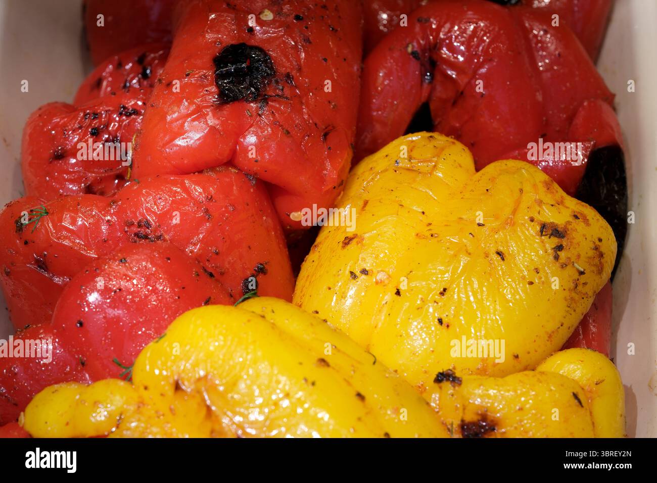 Freshly roasted yellow and red bell peppers showcase their rich colors ...