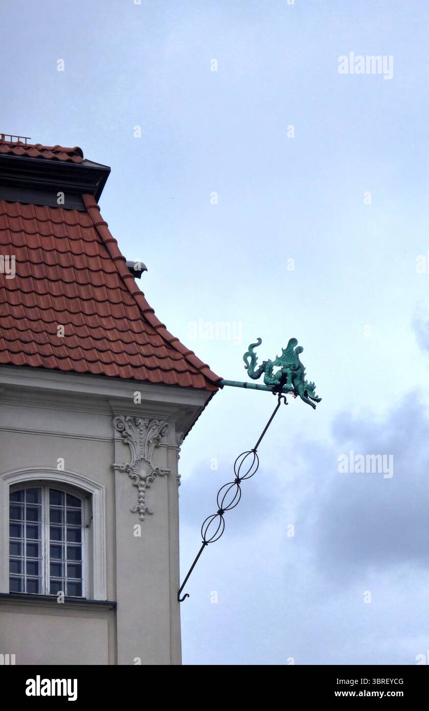 A small bronze dragon sculpture decorating an old building at plac Zamkowy in the old town of Warsaw, Poland. - Smartphone Captured Stock Image
