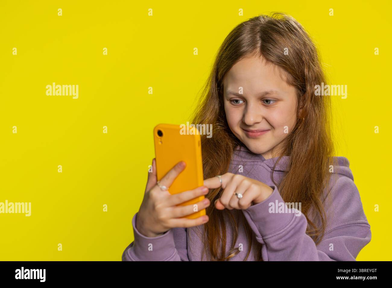 Portrait of young preteen child girl kid using mobile smartphone typing ...