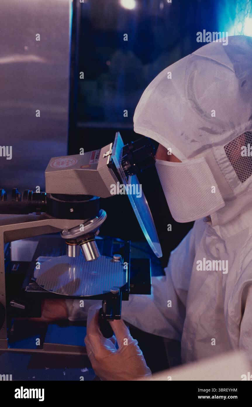 Taiwan. Electronic components industry. Technician checking semiconductor with microscope. Stock Photo