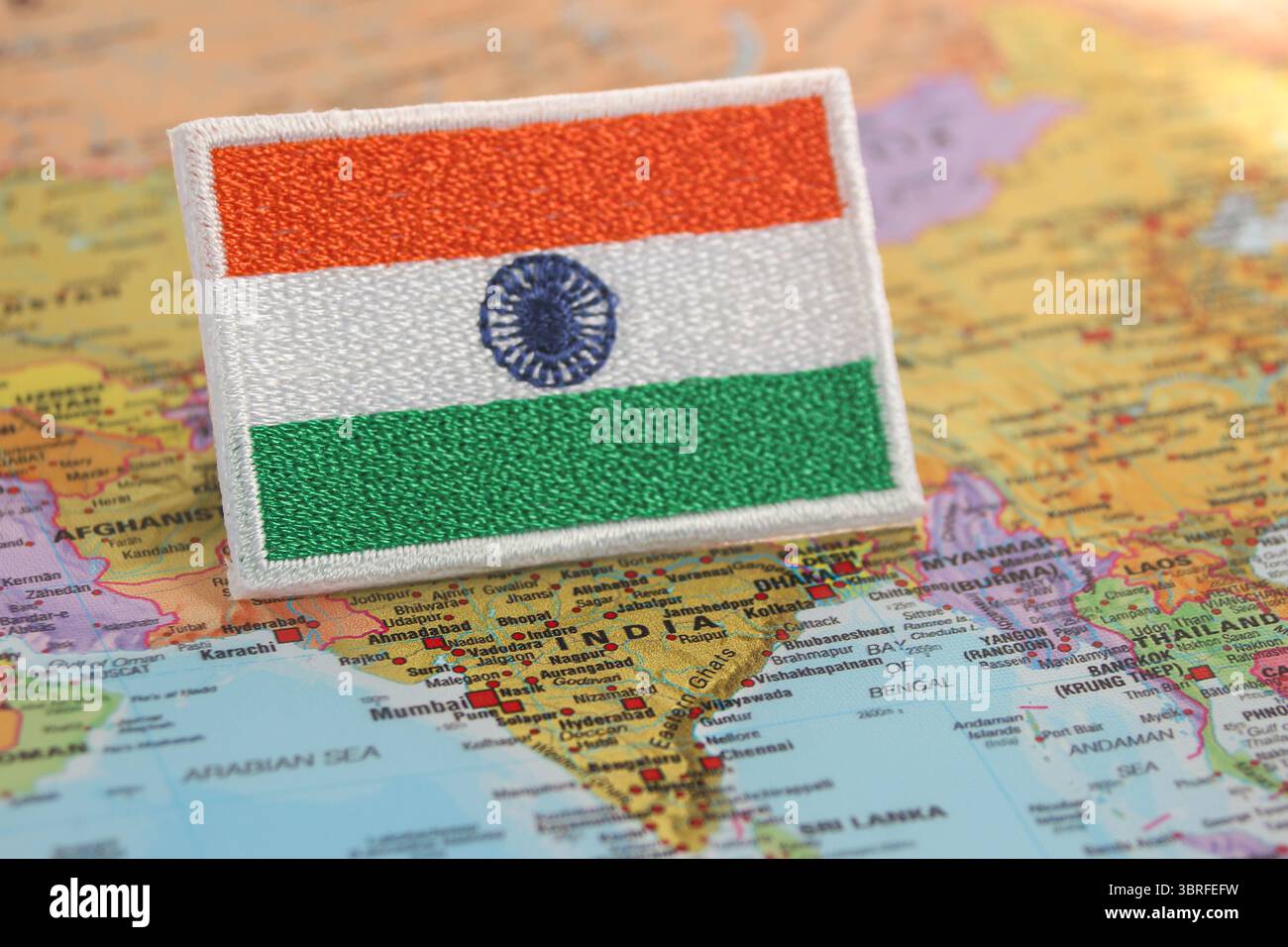 Eco-friendly embroidered Indian flag placed on a world map over India, symbolizing slow travel, nature connection, and sustainable culture. Stock Photo