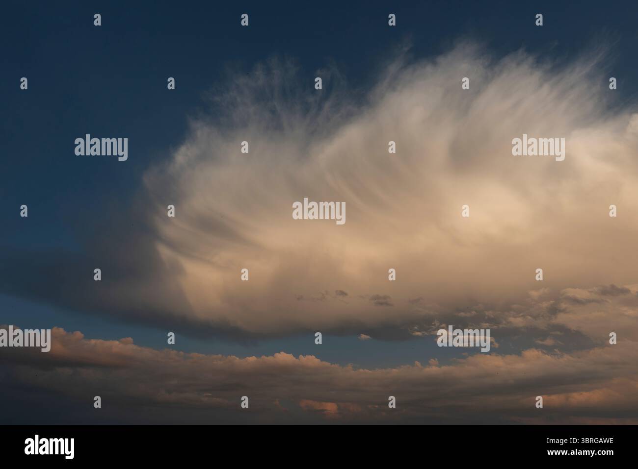 a beautiful picture of clouds, feathery clouds in the light of the setting sun, fluffy cloud against the blue sky Stock Photo