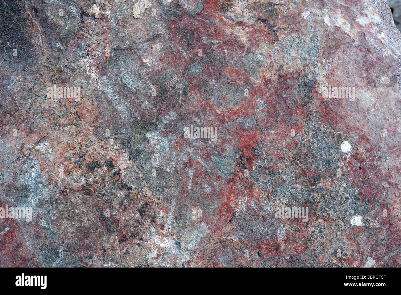 Vibrant patterns emerge on a weathered stone surface, telling stories. Stock Photo
