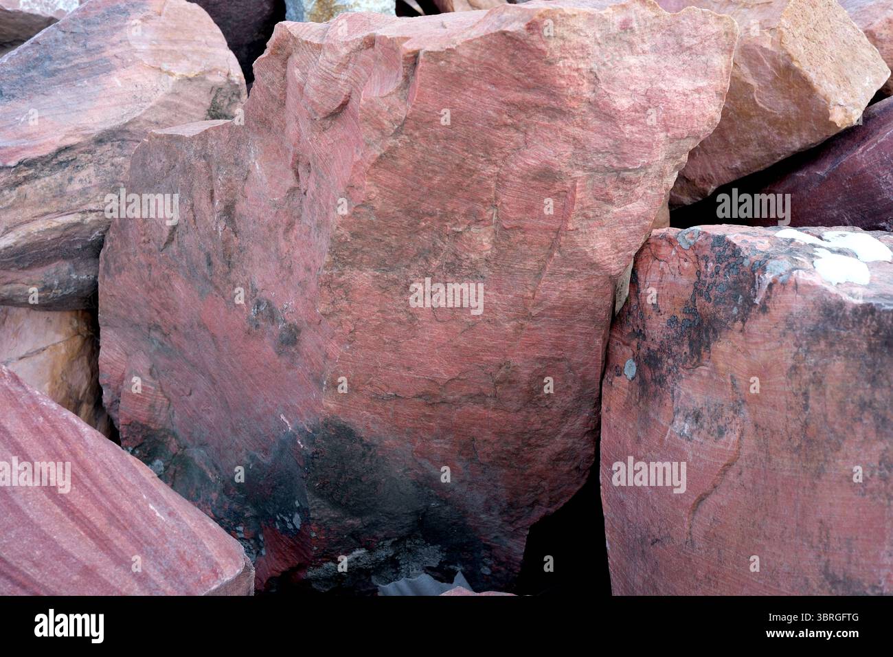 Textured rocks reveal stunning colors under the warm sunlight. Stock Photo