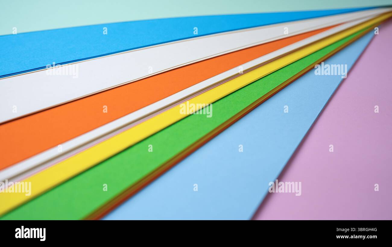 Brightly colored paper sheets are neatly arranged for creative projects. Stock Photo
