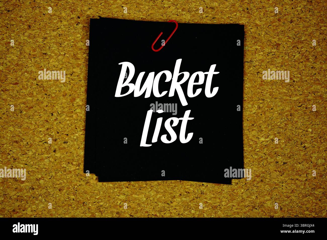 Bucket List text message on stick note on cork paper background Stock Photo