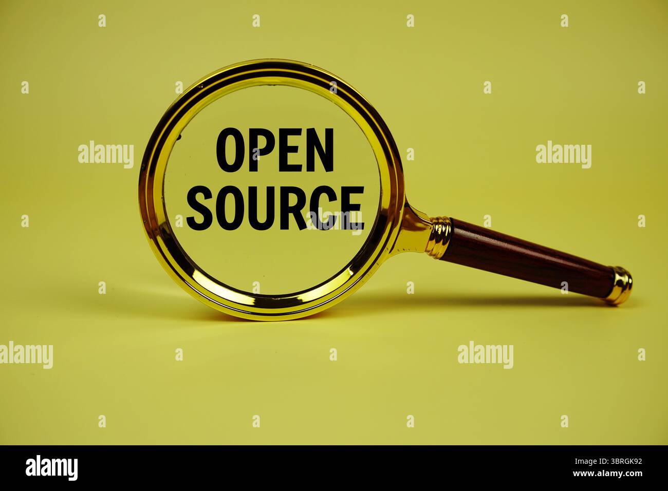 Open Source text with magnifying glass on yellow background Stock Photo
