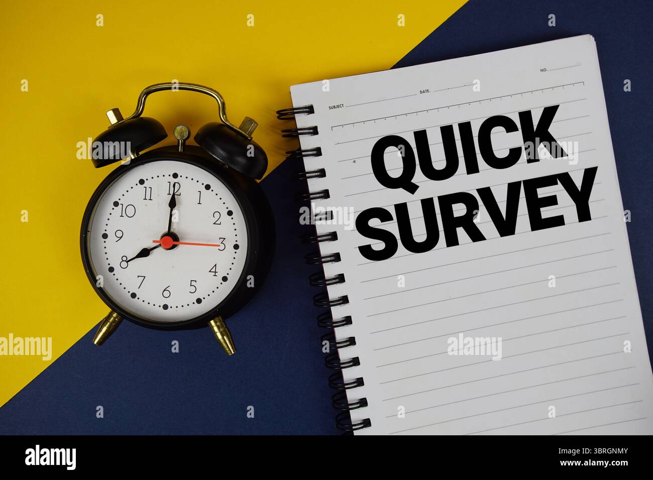 Quick Survey text written on notepad with alarm clock on blue background Stock Photo