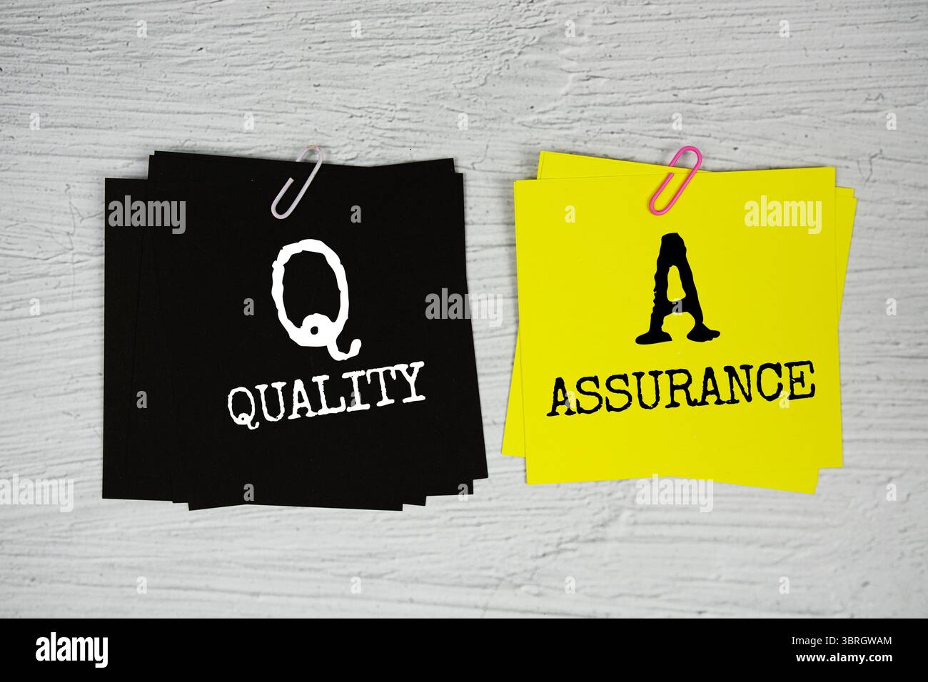 QA - Quality Assurance text on stick note on concrete background Stock Photo