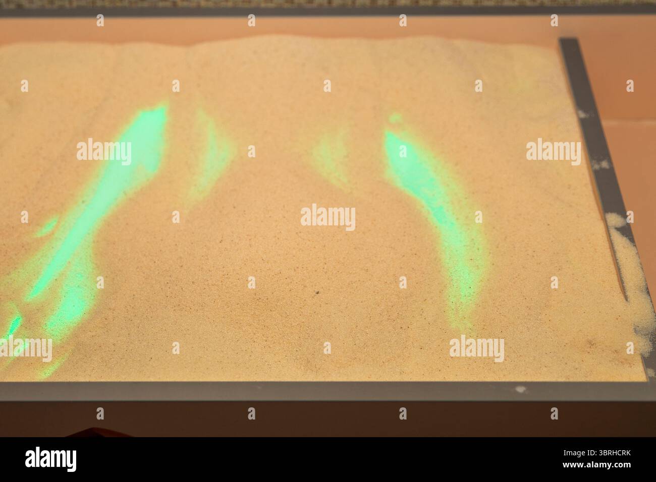 Top view of interactive sand table with glowing green AR projection ...