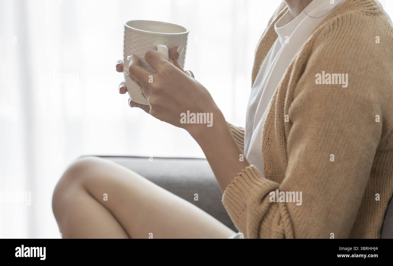 Asian Woman hands holding cup of coffee Stock Photo