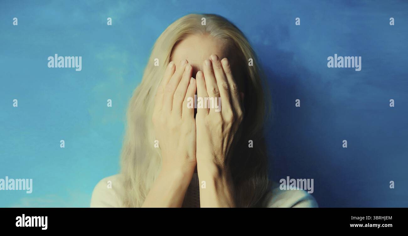 Upset sad crying woman covering her eyes and face with hands while ...