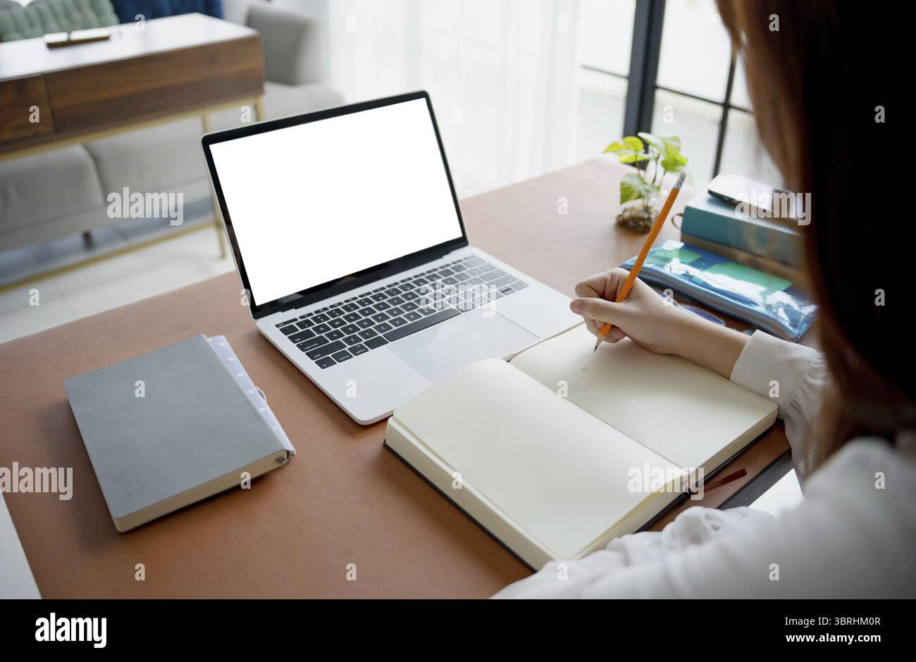 Students sitting at desk using laptop blank screen computer working in office mockup image blank screen computer white background Stock Photo