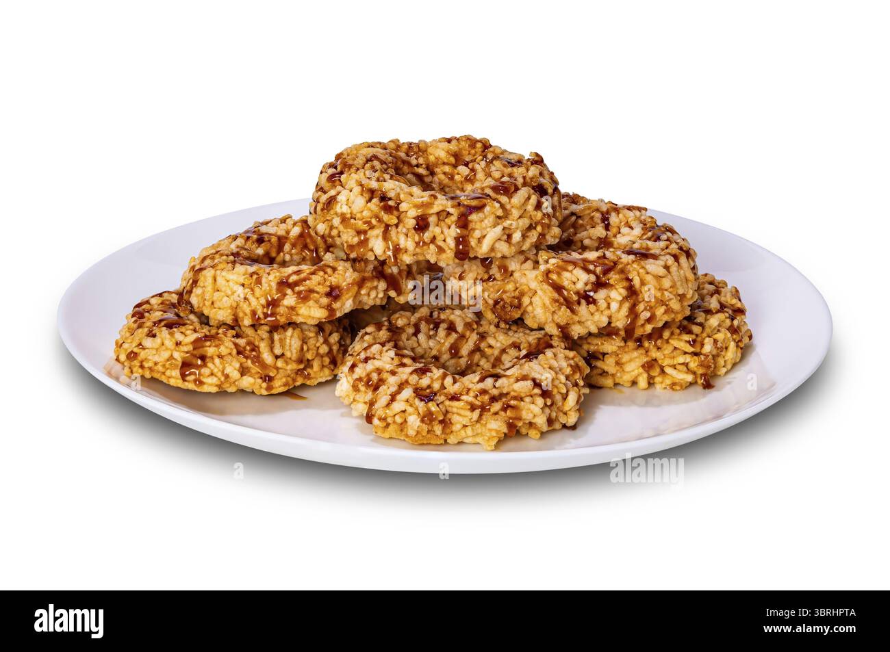 Crispy homemade rice crackers with cane sugar syrup in white ceramic plate isolated on white background with clipping path Stock Photo