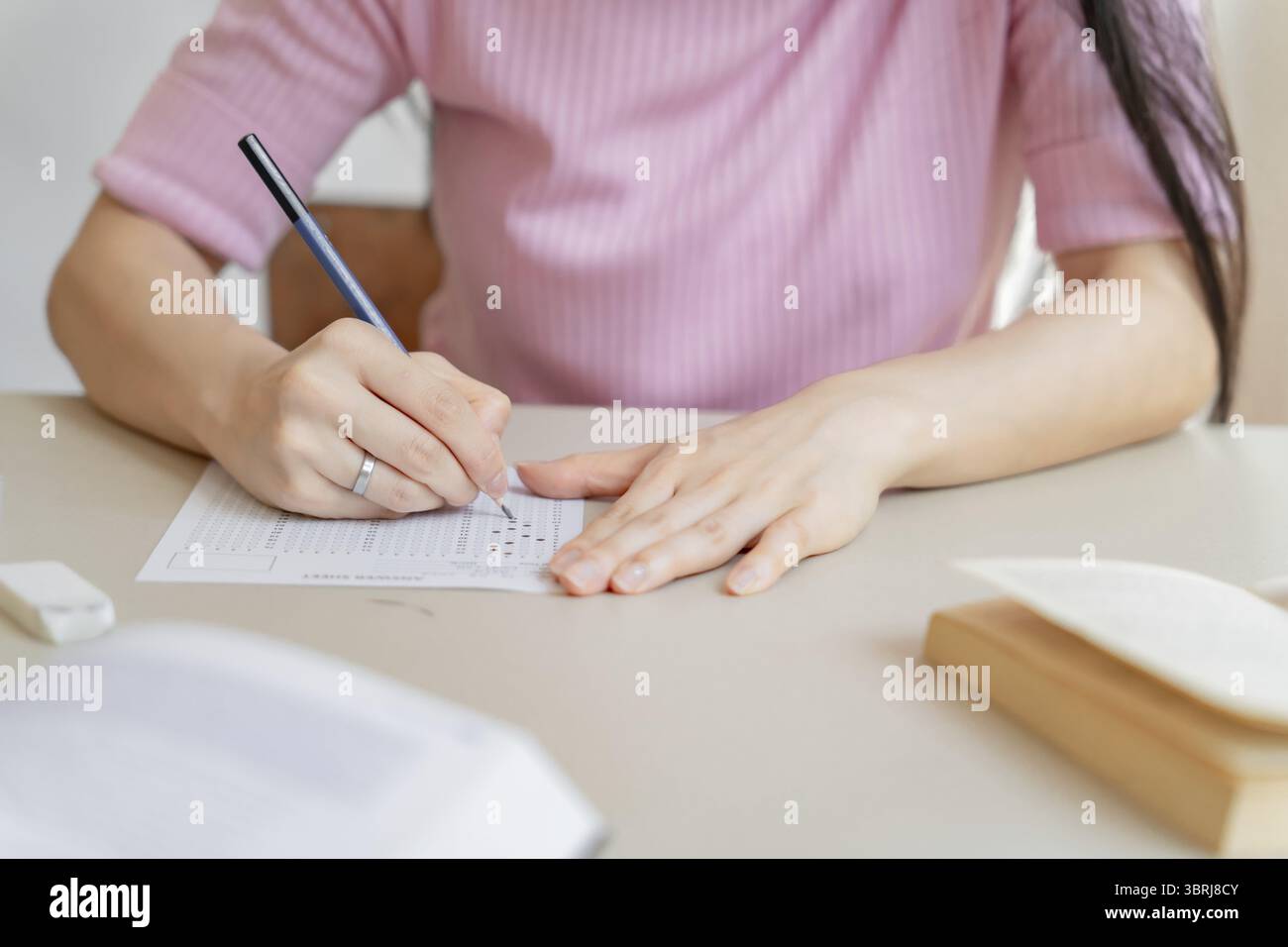 Asian girl student doing exam hand holding pencil writing answer in ...
