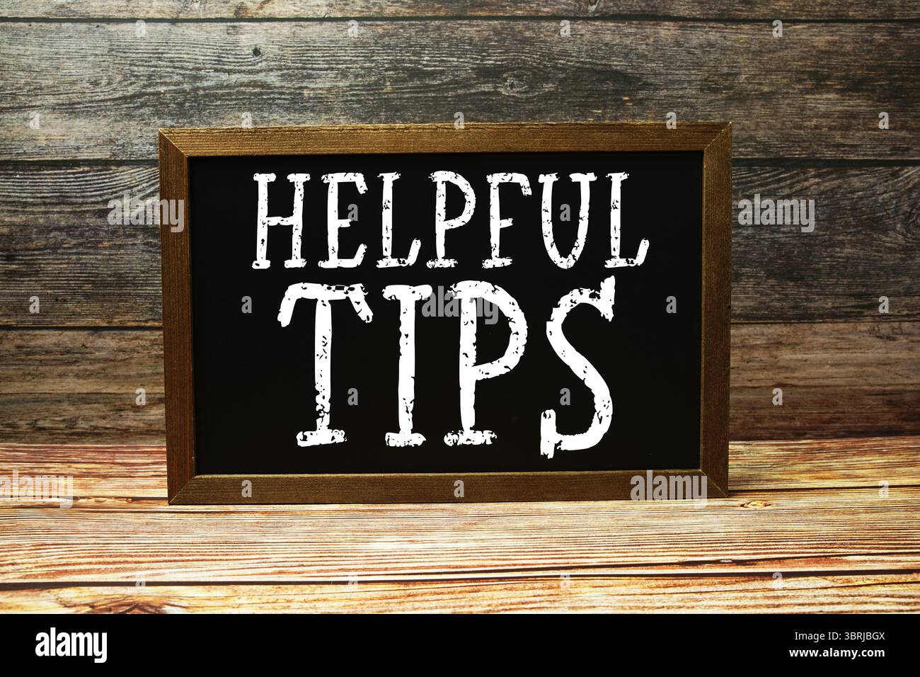 Helpful Tips text with blackboard on wooden background Stock Photo