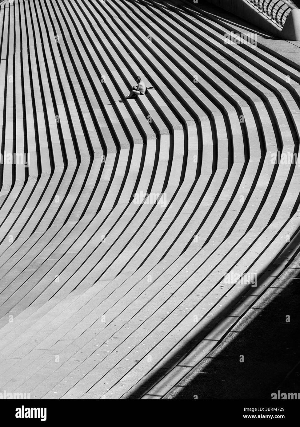 Shadows on the steps of the sea wall at Blackpool with a single figure - Smartphone Captured Stock Image