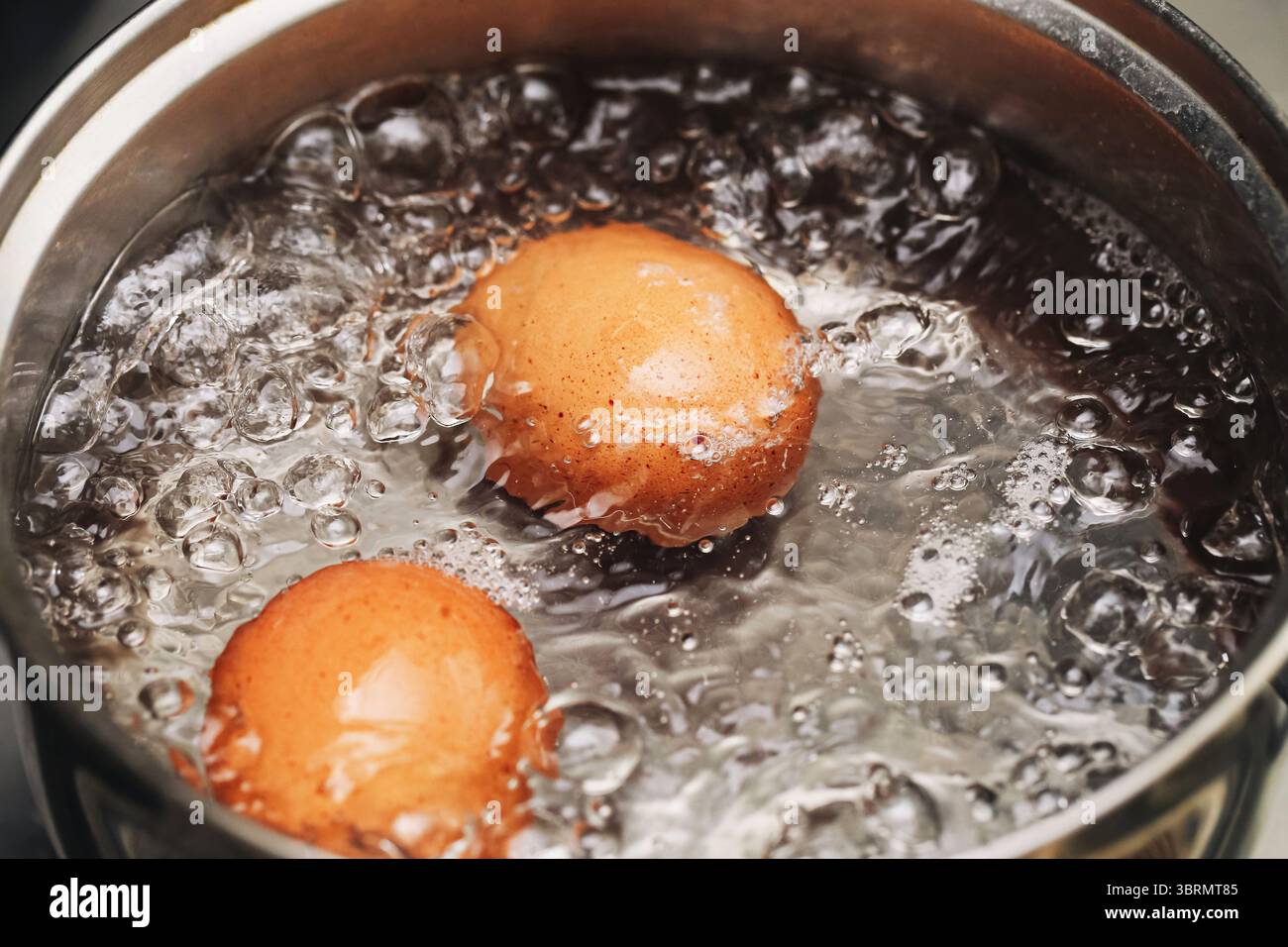 Boiling eggs in hot water. Closeup of eggshell in bubbling pot. Cooking ... - Boiling Egg For An Easy Breakfast In An Egg Cooker