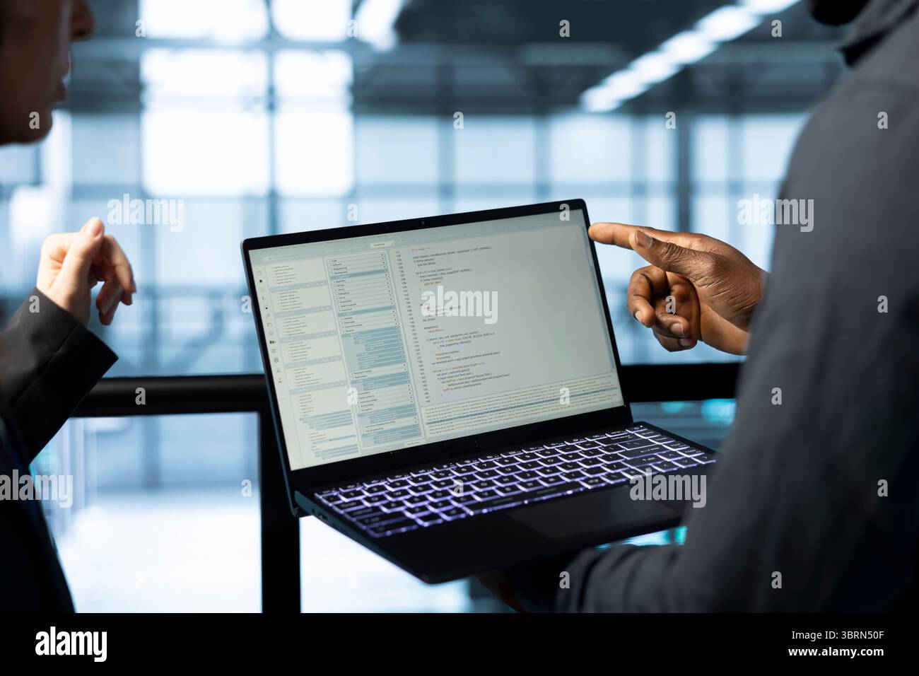 Software developers in data center using laptop, employing machine learning models. Close up of workers using notebook to fulfill infrastructure needs, allocating resources efficiently Stock Photo