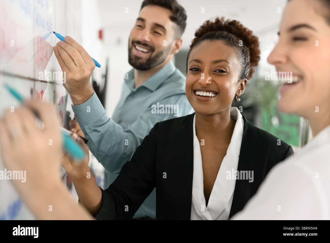 Happy teammates working on plan or project in office Stock Photo