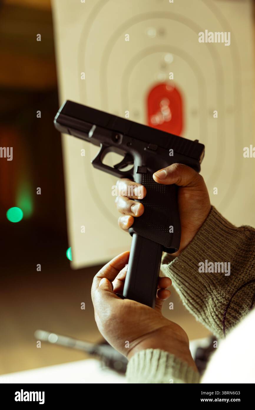 Shooting range client reloading handgun magazine with bullets ...