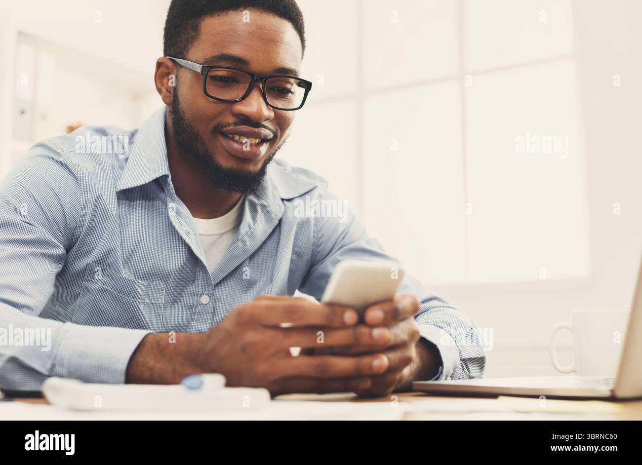 Young black businessman using mobile phone Stock Photo