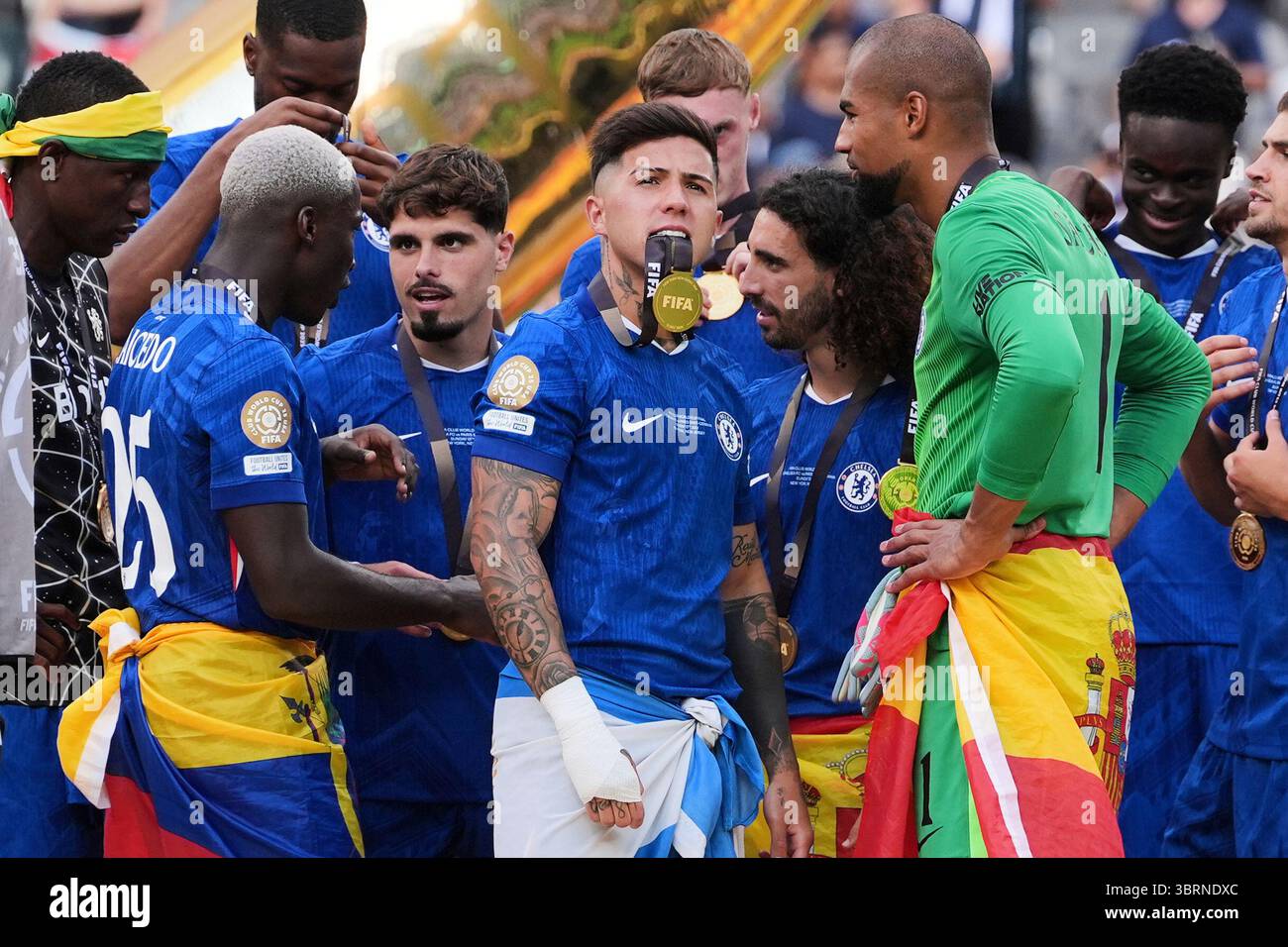 Chelsea's Enzo Fernandez, center, bits the ribbon of his medal ...