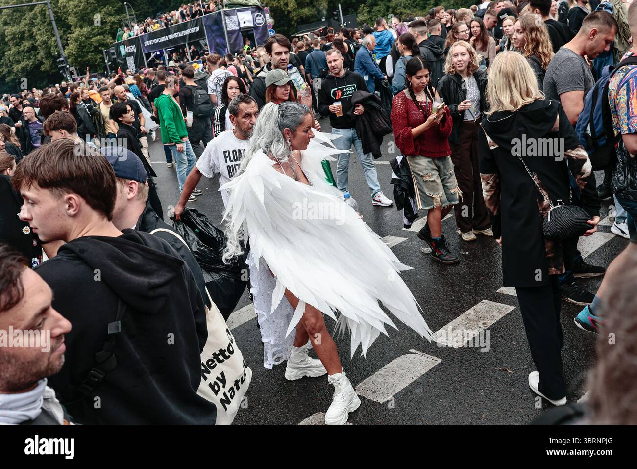 A woman in an angel costume dances among the crowd near the Brandenburg ...